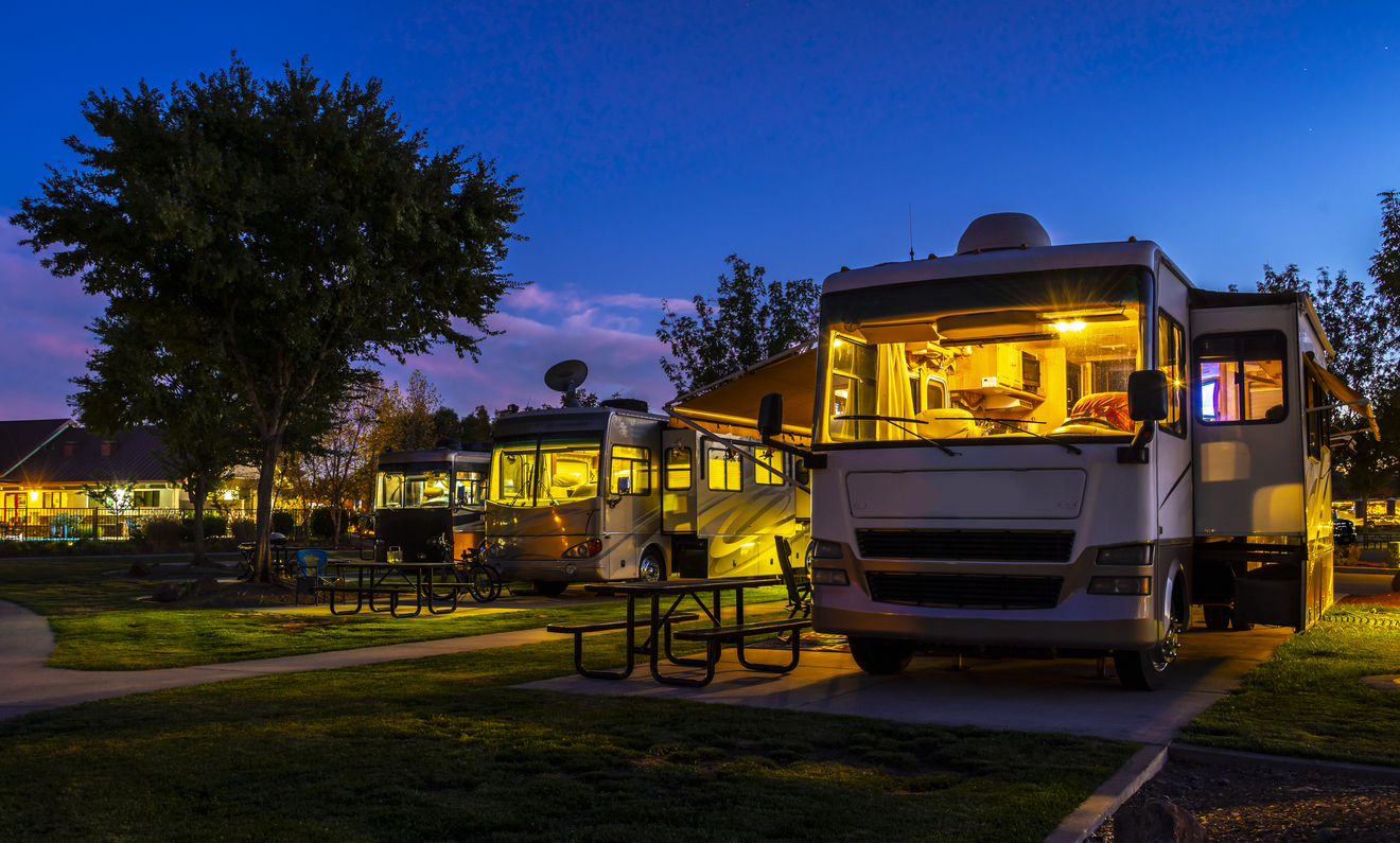 Driving a motorhome - Rving at a resort in the evening lighted sky with class A rigs interior lights on