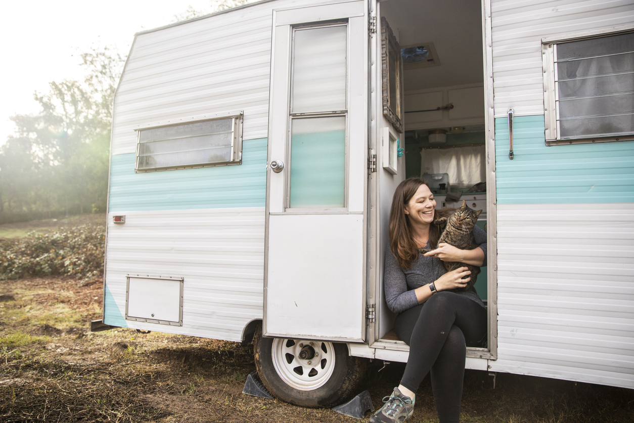 RV with cats - A young woman setting up camp in the wilderness with her trailer