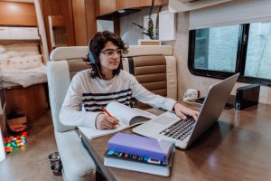 roadschooling - teenager doing homework on motor home