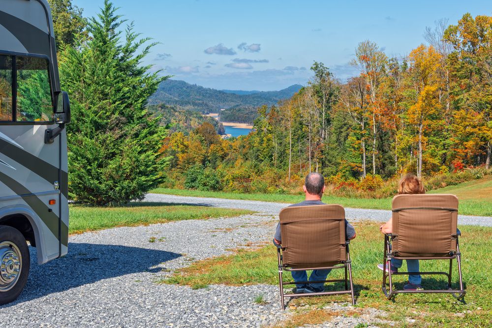 Couple enjoying the view from their campsite outside of a Class A motorhome.