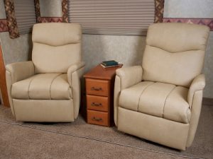Two RV recliners with a cubby storage center in between.