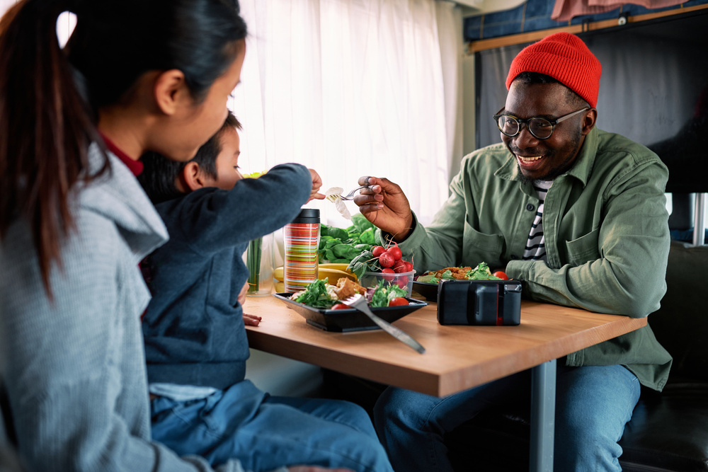 A family eats at a dinette, one of our RV tables, in their motorhome.