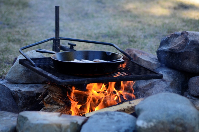 A cast iron skillet is a popular RV accessory for the kitchen. This skillet is cooking breakfast on a campfire grate.