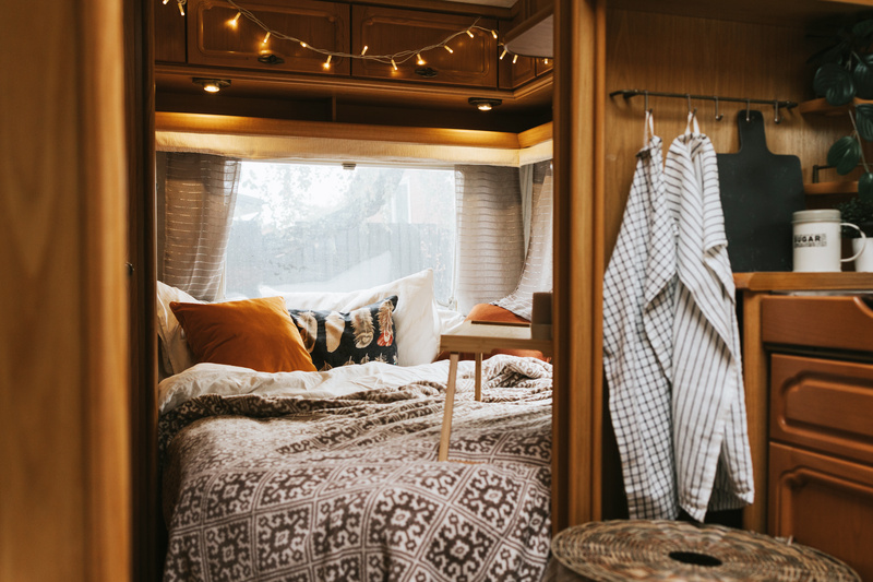 A cozy, naturally styled motorhome bedroom.