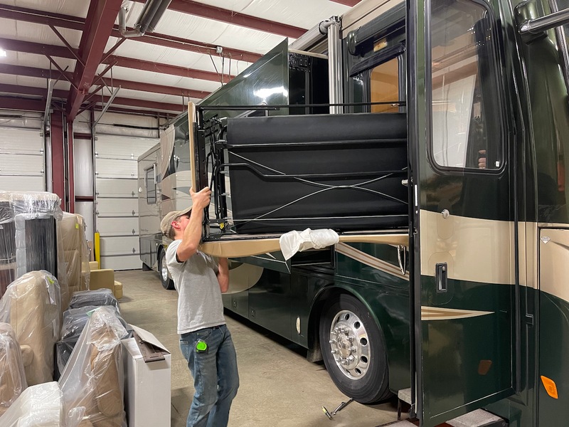 A Bradd and Hall professional loading a new couch into a motorhome. 