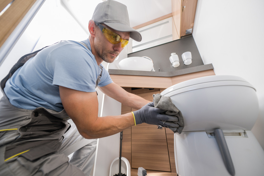 Man cleaning an rv toilet and bathroom